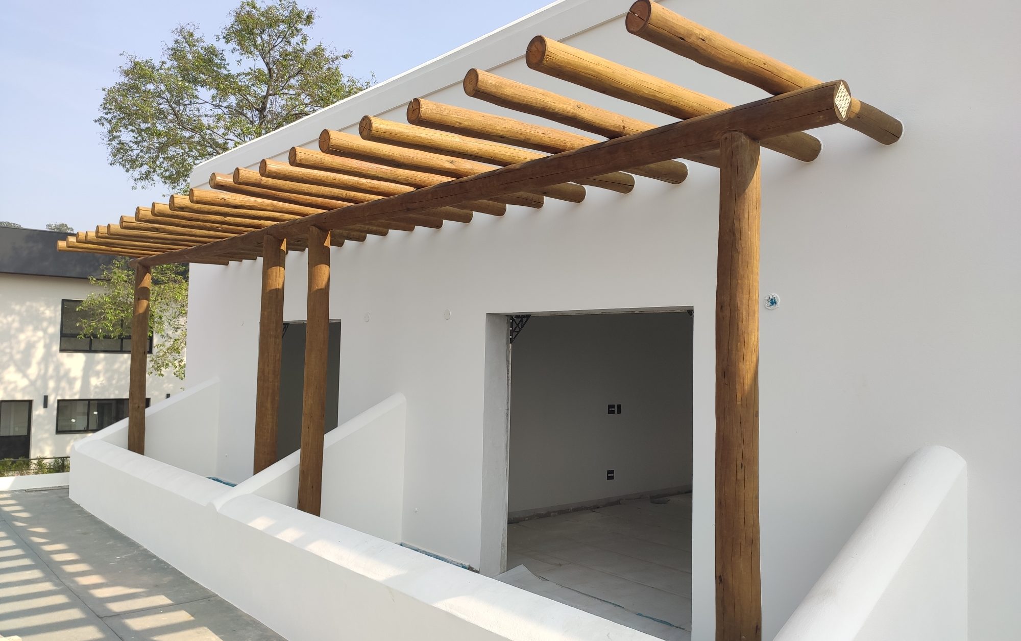 Estrutura de pergolado em eucalipto tratado seguindo o design rústico do Estilo Santa Fé