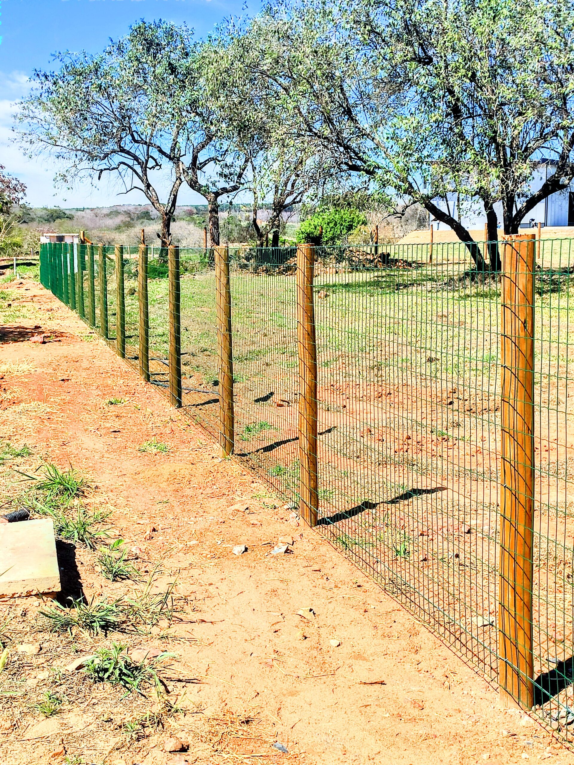 Aplicação de mourões de eucalipto tratado em cercamento residencial