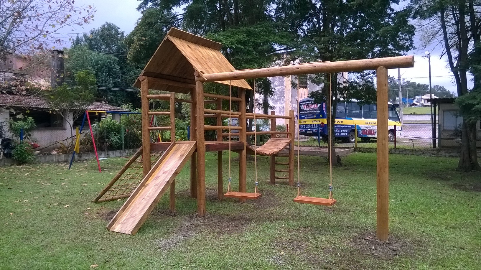 Estrutura de playground com ponte de cordas e madeira tratada