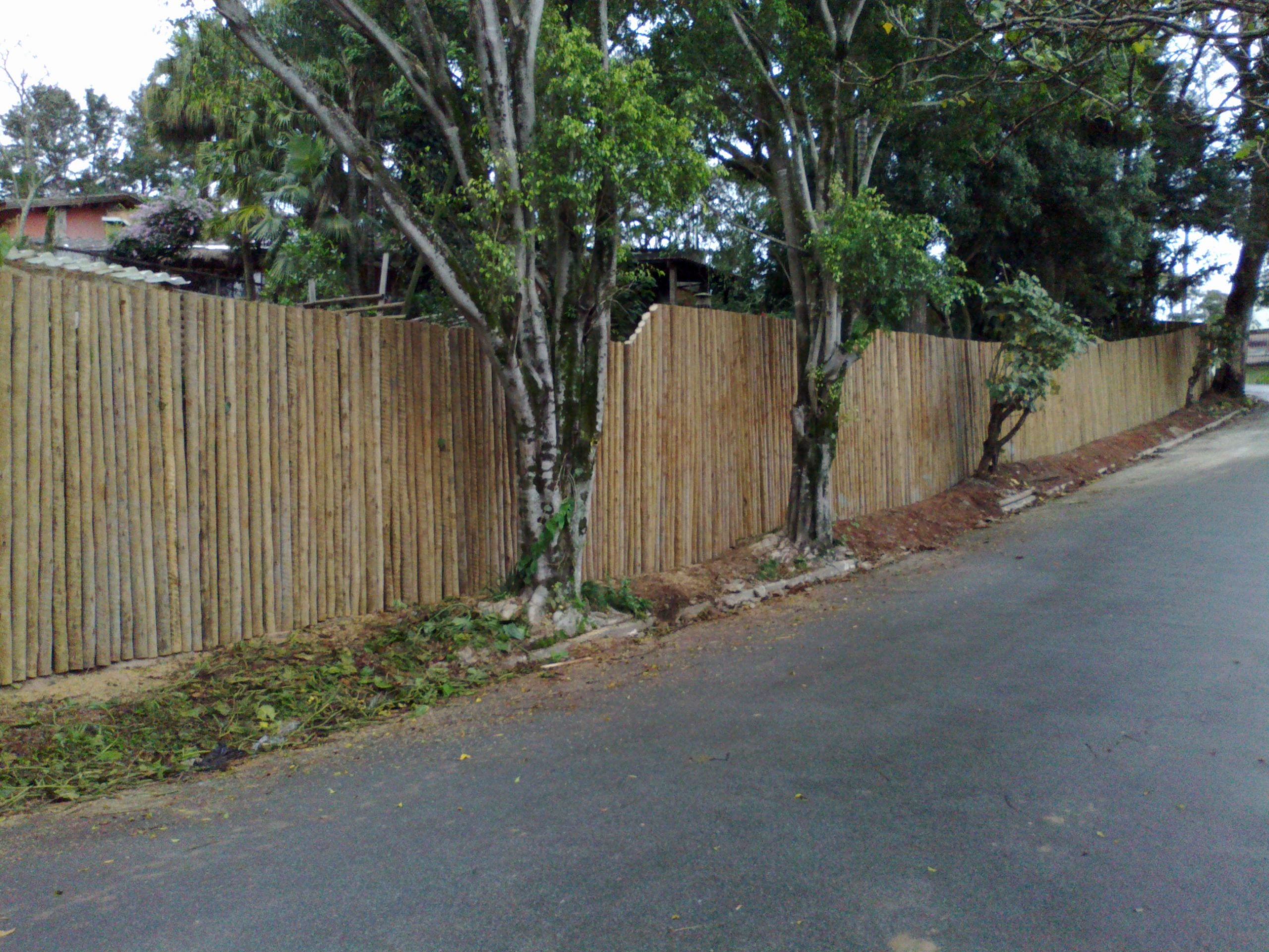 Cerca rústica de eucalipto tratado com mourões alinhados e acabamento premium