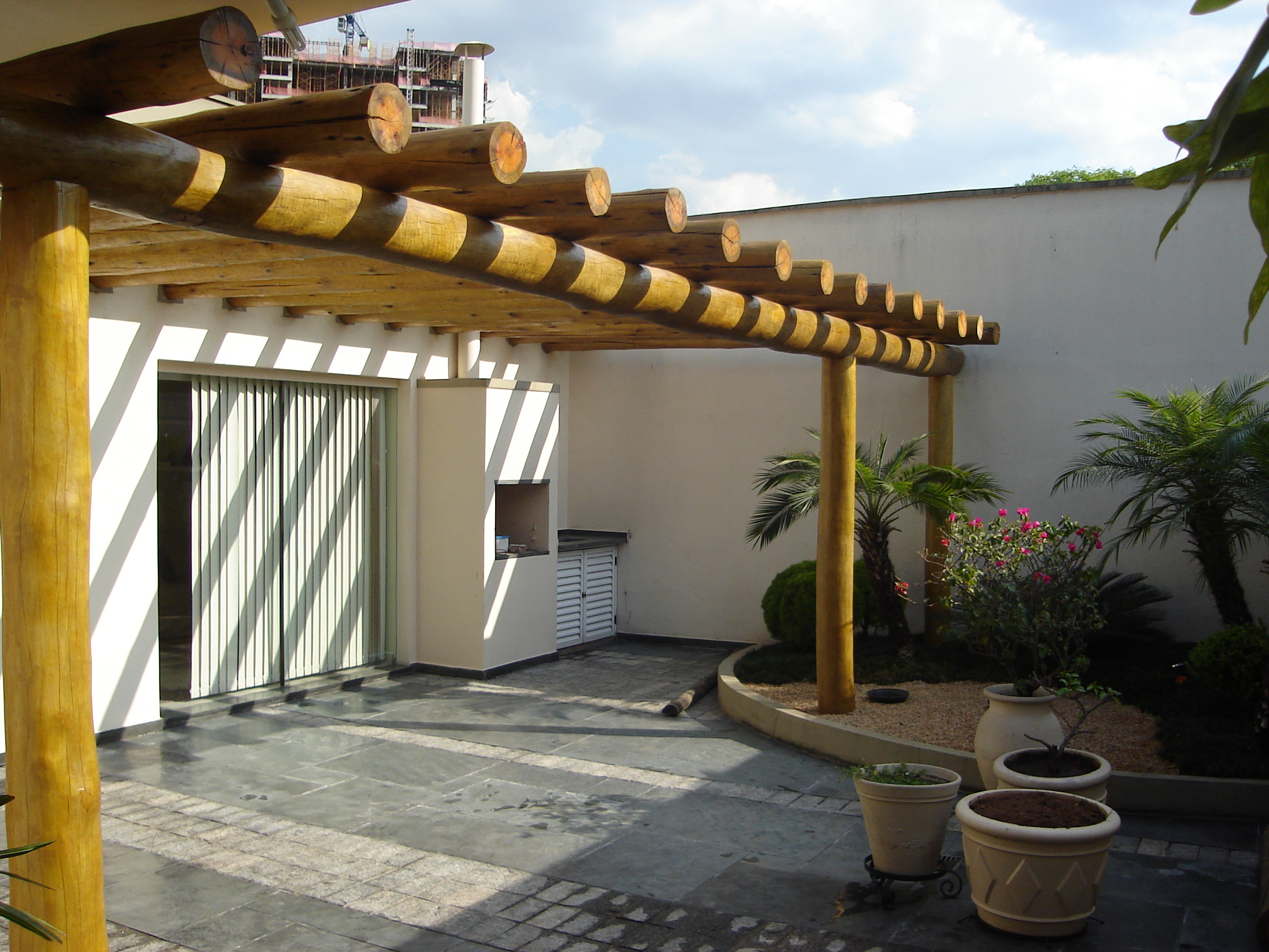 Pergolado de eucalipto roliço em área de piscina