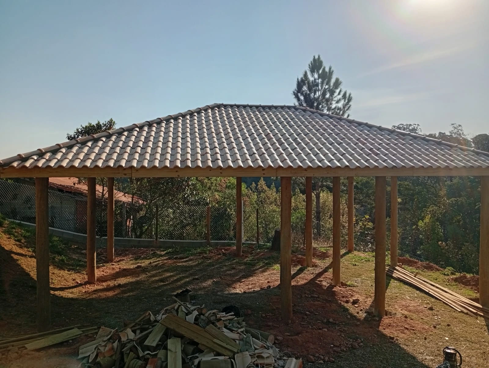 Foto de uma estrutura com telhado de telha cerâmica. Estrutura feita de eucalipto tratado