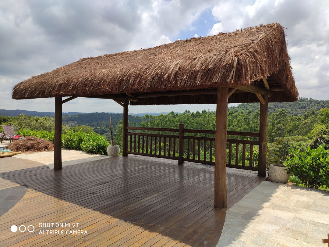 Quiosque de piaçava e eucalipto tratado em jardim residencial